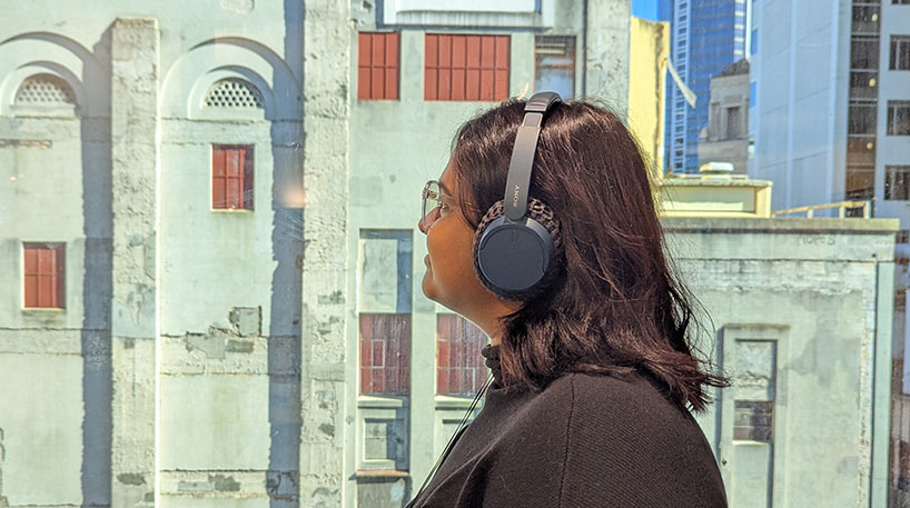 Woman with headphones looking at a building